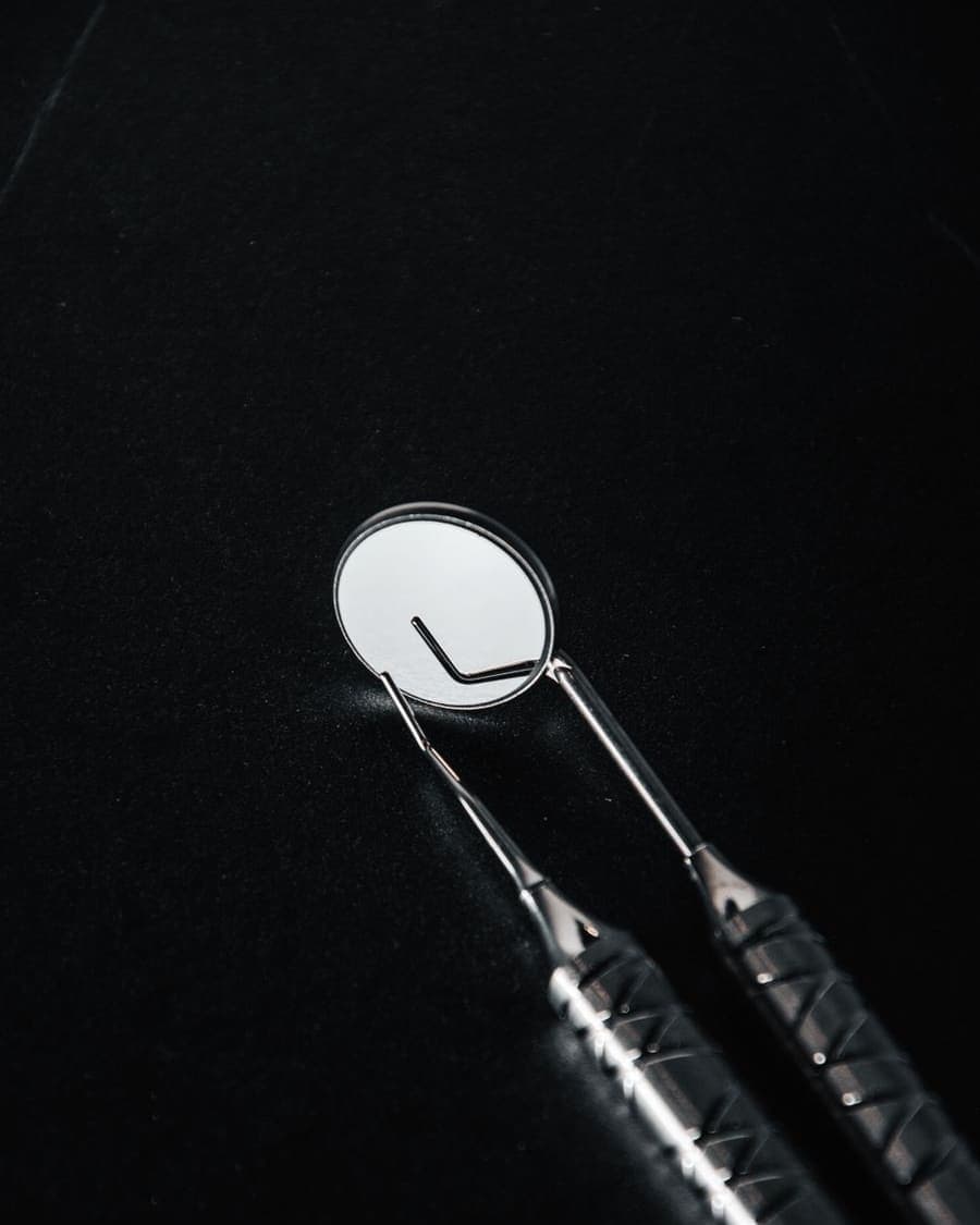 Miroir et sonde dentaires posés sur fond sombre